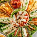 A platter of sandwiches & wraps featuring various fillings