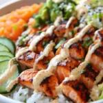 Salmon Rice Bowl served in a bowl with avocado and cucumber